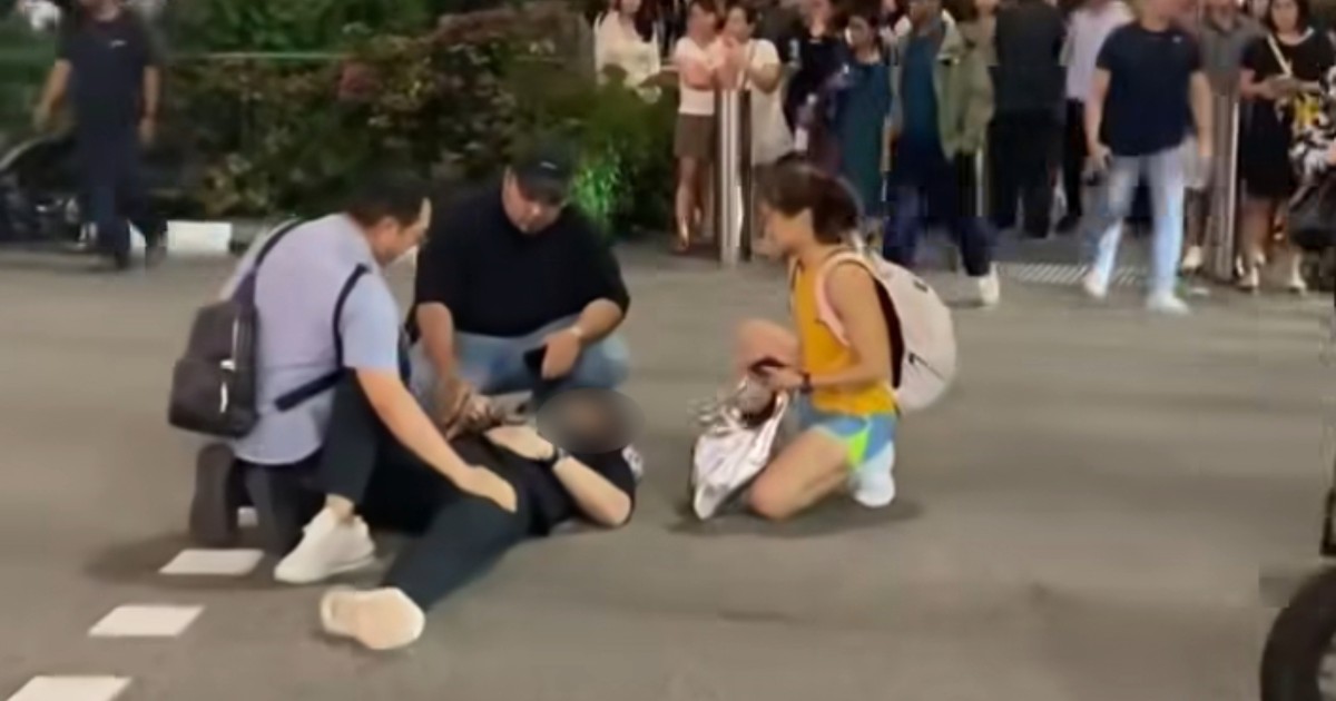 Passers-by assist man seen lying on Orchard Road pedestrian crossing after motorcycle accident