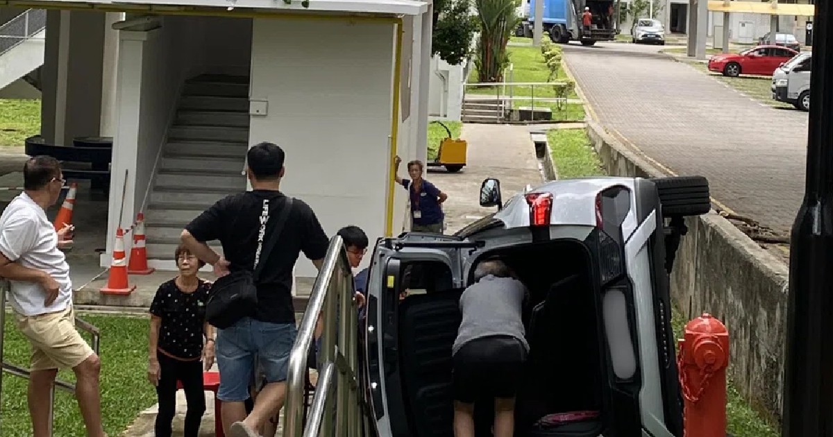 Car flips onto its side next to HDB block in Bedok, believed to have skidded